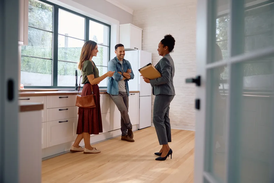 Agent and buyers talking through a kitchen during a tour